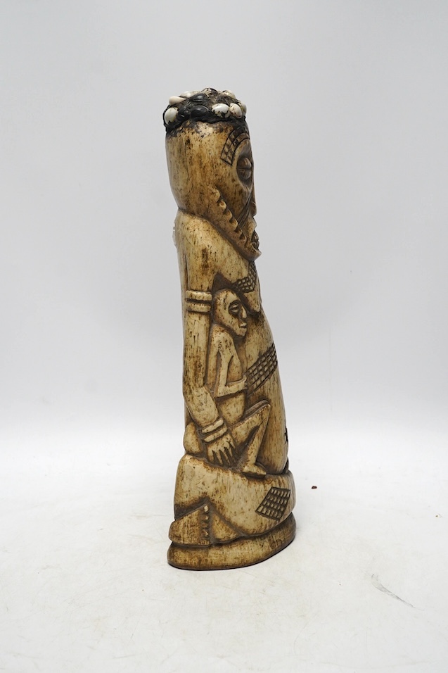 A West African carved animal bone fertility figure, 34cm. Condition - fair